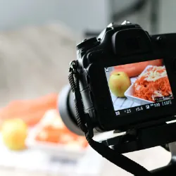 Camera focused on apple and food on table